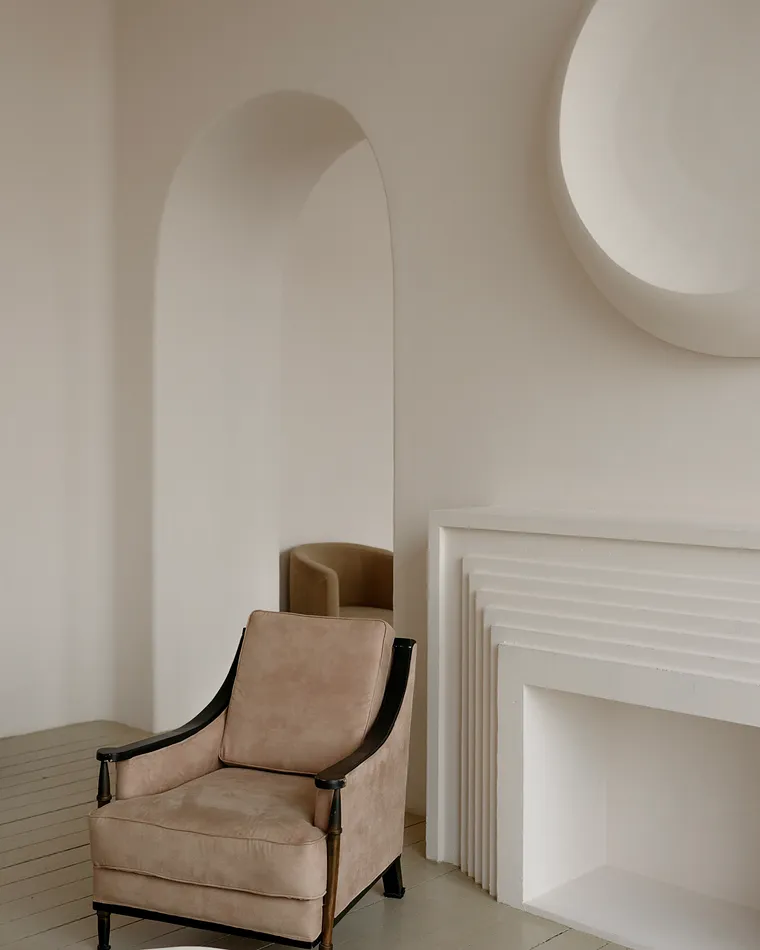 Interior de atelier com bancada baixa, cadeira de couro e luz difusa