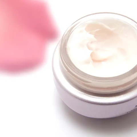 Creme espesso e claro num frasco aberto.