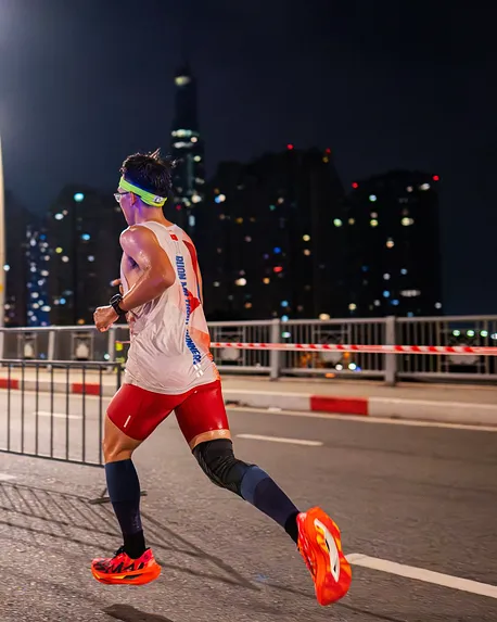 Pessoa a correr numa rua da cidade à noite, fotografia provisória.