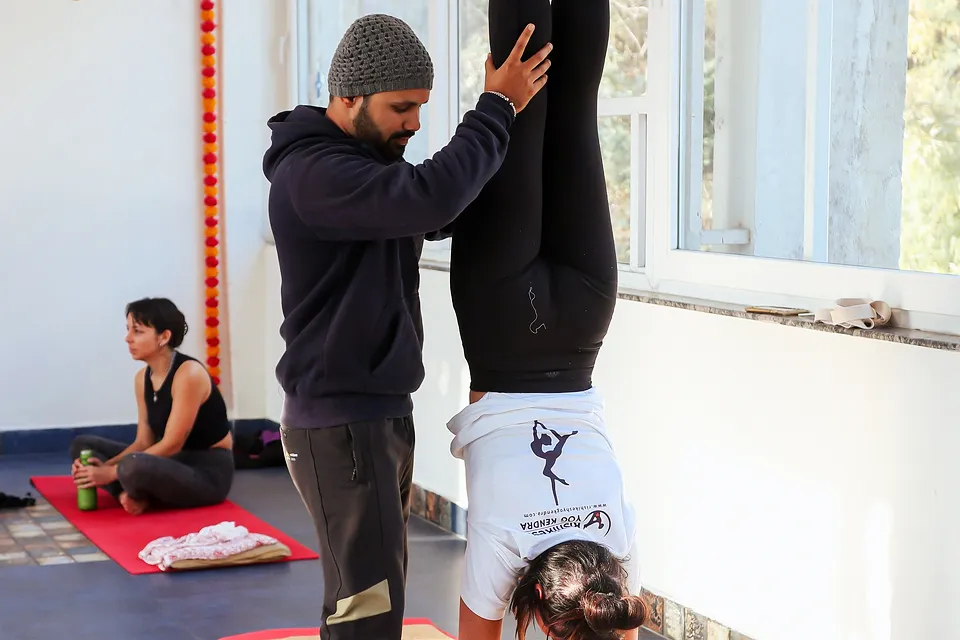 Alguém acompanha outra pessoa num exercício, numa sala clara, fotografia provisória.