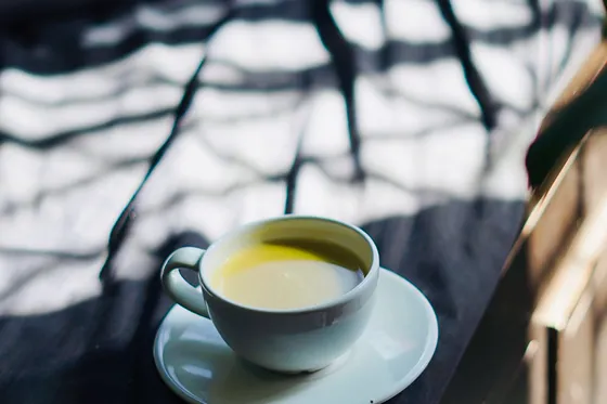Chávena de café de especialidade numa mesa branca, fotografia provisória.