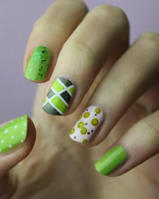 Nail art em verde lima com pintas e um losango geométrico.